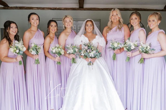 Serving bridesmaid energy next to the ultimate princess bride — our one-shoulder multiway dress in Heather is a whole vibe.

Custom looks, effortless glam, endless compliments.
Gorgeous memories 📸

#BridesmaidTrend #HeatherHues #StyledYourWay #katesdresses #lavenderbridesmaidsdress #lilacwedding #bride2026
